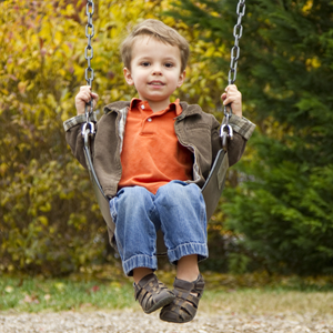 A young child swinging on a swing.