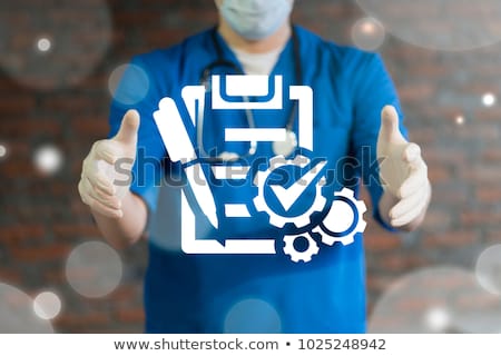 A person wearing surgical scubs and a stethoscope with arms outstretched.  Between the person's open arms are a collection of emblems to represent data, including an electronic health record, cogs and wheels, a pen.