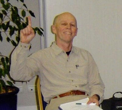 Dr. Ed Helton making the number one gesture with finger. 