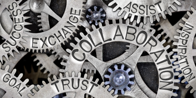 A series of gears with labels collaboration, exchange, success, assist, inspiration, trust, and goal, are all fitted together in a single image. It shows the value of all these things working together in a synchronized machine.