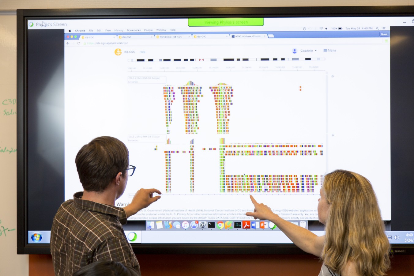 Researchers reviewing and sharing data on a projector screen