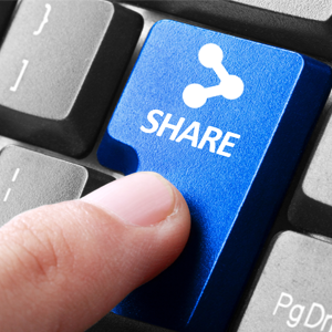 Photo shows a blue button on a computer keyboard with the words "share." 