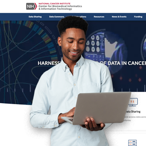 Young Black Man wearing a light blue button looking down at a silver laptop. The CBIIT homepage is the background, with tagline: Harnessing the Power of Data in Cancer Resesarch