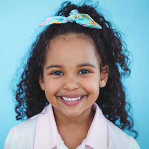 Girl with black curly hair and a bow with a light blue background