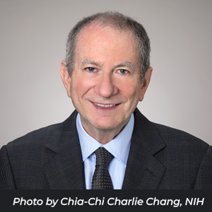 Professional headshot of Eric "Rocky" Feuer. Text reads, "Photo by Chia-Chi Charlie Change, NIH"