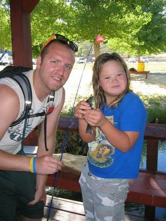 Joe and a young camper show the fish they caught