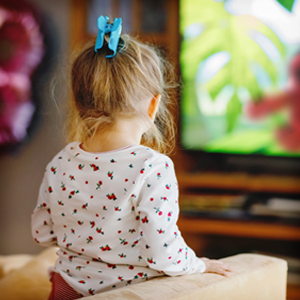 child looking at a tv screen with a portion of red teddy bear on the screen