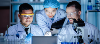 Image of three researchers in a laboratory looking at computer screen.