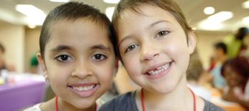 Image of two children smiling broadly